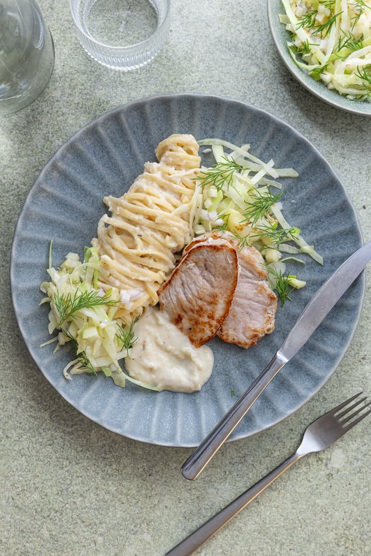 Sellerikremet pasta med filetstykke av svin, servert med lun kålsalat med eple og dill