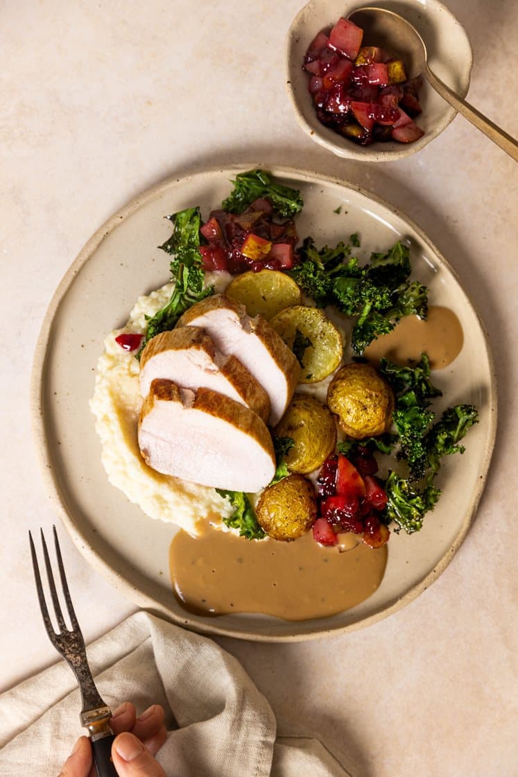 Helstekt svinefilet med tyttebærglasert pære, sellerirotpuré, soppsaus og ovnsbakte potetskiver med grønnkål