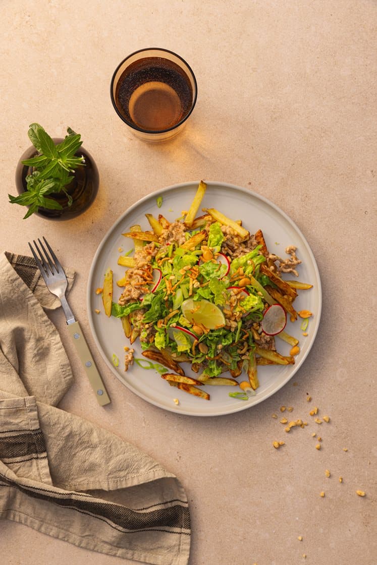 Loaded fries med spicy, kremet kjøttdeig, toppet med sprøstekt ingefær, peanøtter og lime