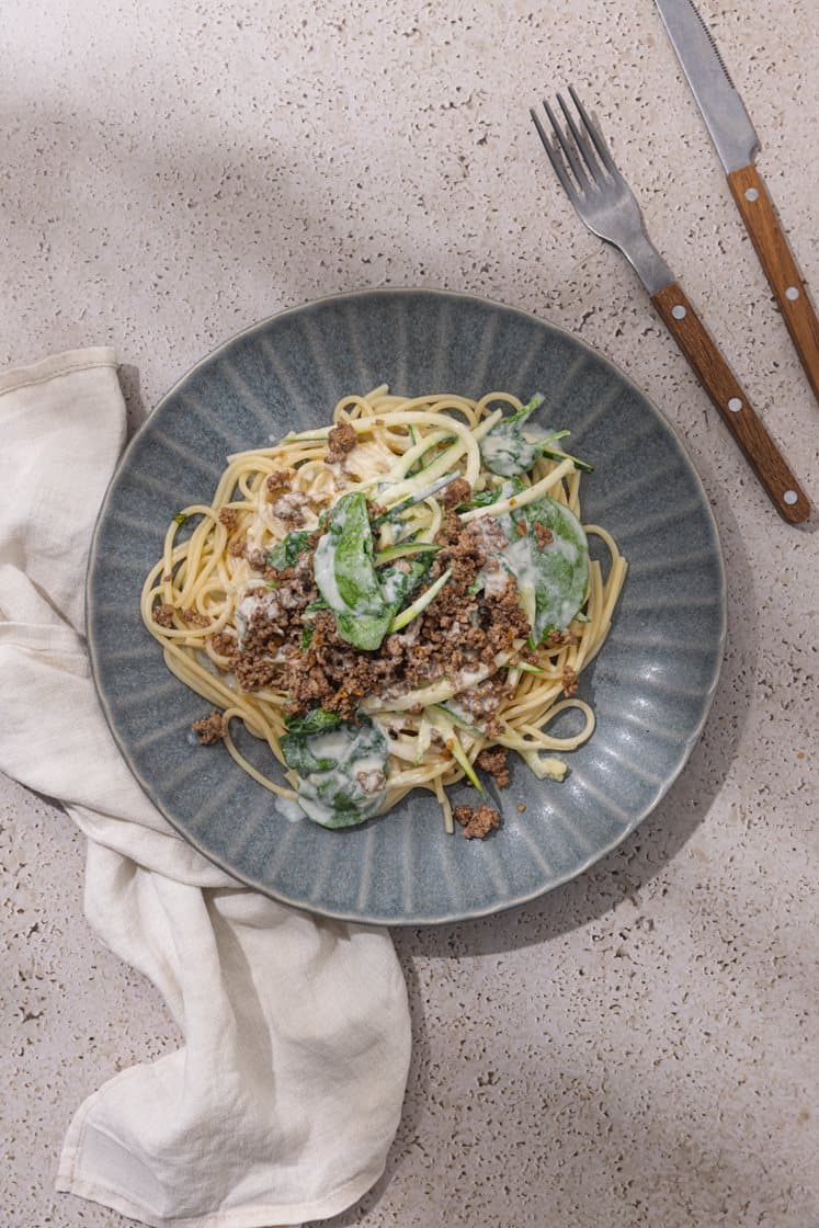 Linguine og squash-spaghetti i mild ostesaus, servert med sprø kjøttdeig og spinat 