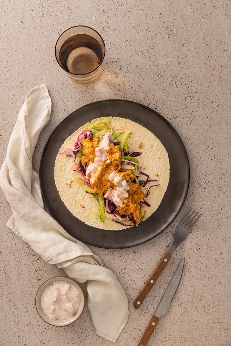 Indisk wrap med butter chicken og kålsalat, servert med tomatraita