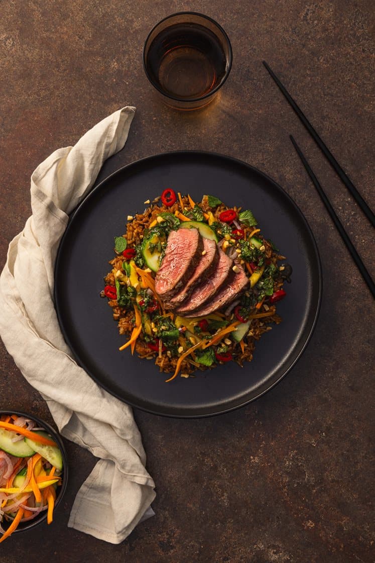 Asiatisk biff-salat med spicy stekt ris, servert med mango, mynte og sesamdressing