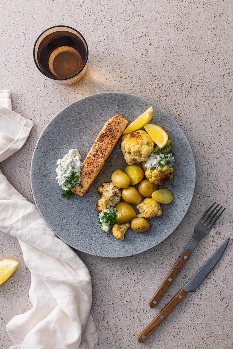 Ovnsbakt laks med poteter og smørstekt blomkål, servert med eple- og gressløkdressing