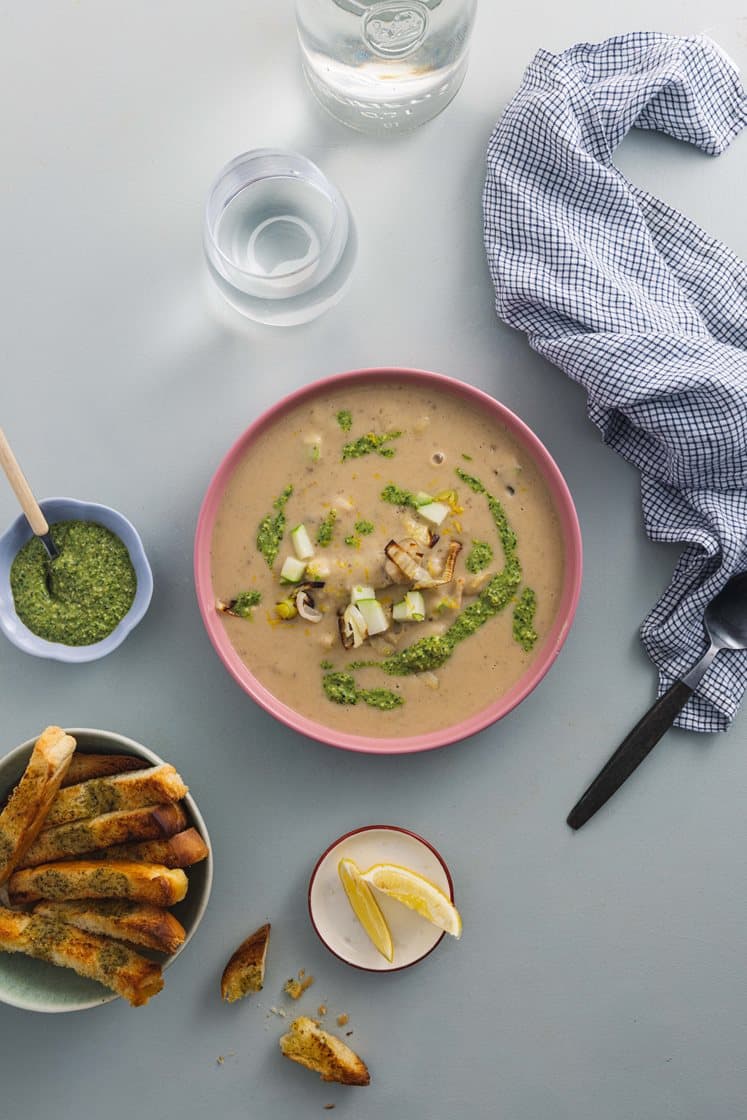 Kremet jordskokk- og potetsuppe servert med purrepesto og brødsticks